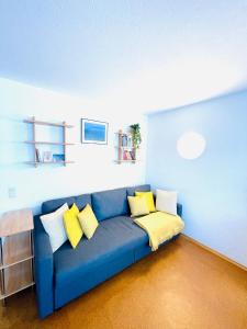 上施陶芬Mountains–Allgäu Living – 40sqm的客房内的蓝色沙发,配有黄色枕头