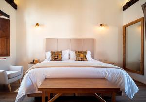莱瓦镇Hotel Casa Alcestre的一间卧室配有一张大床和一把椅子