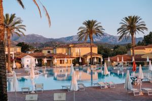 布多尼Valtur Baia dei Pini的酒店游泳池设有椅子和棕榈树