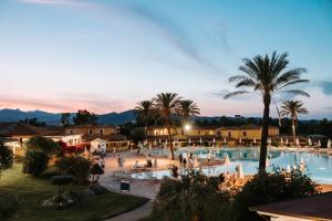 布多尼Valtur Baia dei Pini的一个带棕榈树大型游泳池的度假酒店