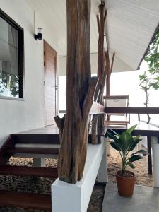 苏梅岛Boon Heritage House Koh Samui的树立雕塑,坐在房子的楼梯上