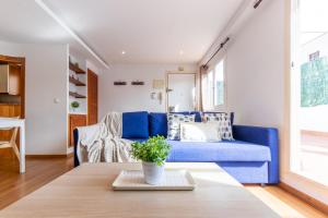 塔拉戈纳WOOOW!!! Àtic Cèntric amb Terrassa的客厅配有蓝色的沙发和桌子