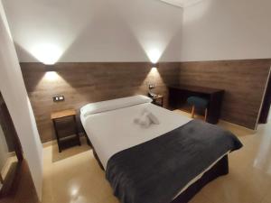 毕尔巴鄂Hotel Artxanda Bilbao的卧室设有白色大床和木墙