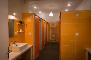 卡兰巴卡The Holy Rock - Hostel at meteora的浴室设有橙色墙壁、水槽和镜子