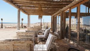 达赫拉Desert Sands Dakhla的海滩上一座带桌椅的建筑