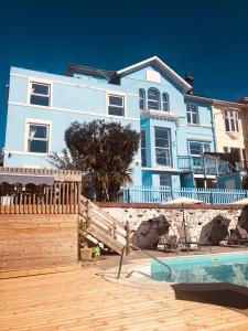 托基The Purple Tree Guest House的蓝色的房子,前面有一个游泳池