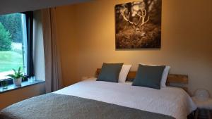 斯图蒙Le Clos du Cerf - Silence & nature的卧室配有一张挂着鹿画的床。