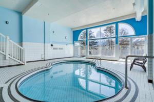 坎莫尔Chateau Canmore的室内游泳池拥有蓝色的墙壁和窗户