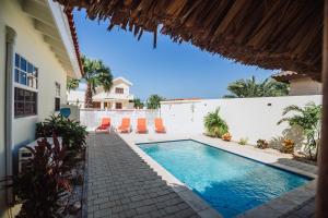 棕榈滩Dushi Villa的一座带房子的庭院内的游泳池