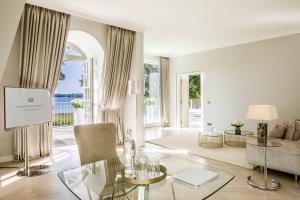巴特萨罗皮斯库夫Villa Contessa - Luxury Spa Hotels的客厅配有玻璃桌和沙发