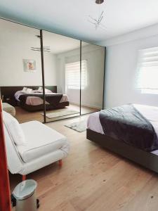 CASA BOUTIQUE LOS MONEGROS的一间卧室配有镜子、一张床和一把椅子