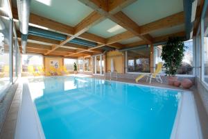 瓦尔内明德戈德温酒店的一座拥有木制天花板的酒店的大型游泳池