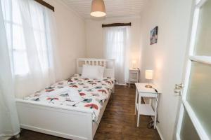 帕诺尔莫斯斯科派洛斯Avli Townhouse的白色卧室配有床和桌子