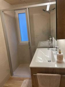 萨斯格伦德Apartment Bellavista的浴室配有盥洗盆和带镜子的淋浴