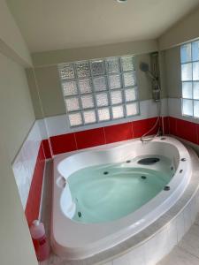 拉利伯塔德Hotel y Restaurante Rincón Familiar的带浴缸的浴室,铺有红色瓷砖