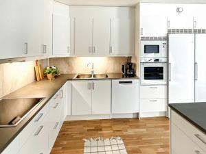 ArkösundHoliday home VIKBOLANDET II的白色的厨房配有白色橱柜和水槽