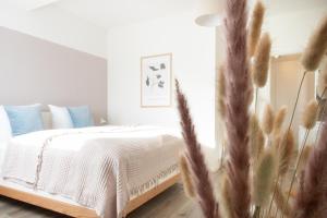 诺伊豪森Löwe Apartments "Blau" Neuhausen am Rheinfall的一间卧室配有带白色床单和蓝色枕头的床。