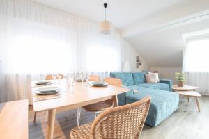 诺伊豪森Löwe Apartments "Blau" Neuhausen am Rheinfall的客厅配有桌子和蓝色沙发