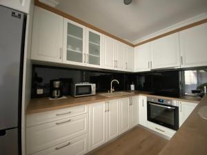 克卢日-纳波卡Central Park Apartment的厨房配有白色橱柜、水槽和微波炉