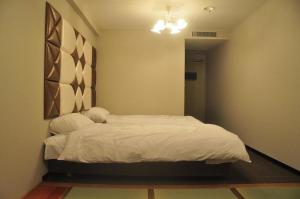 IidaHakuba Sun Valley Hotel Annex - Vacation STAY 90351v的卧室配有白色床和吊灯