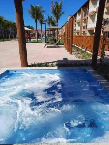 塞古罗港Apart Resort Beira Mar Mutá - PS的一座建筑旁边的蓝色海水池