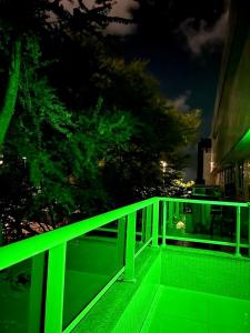 若昂佩索阿Beira Mar Premium Apart - Solar do Atlântico Tambaú的夜间在阳台上的绿色栏杆