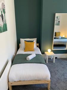 盖茨黑德Kitchener - Wonderful 2-Bedroom Apt Sleeps 5 Free Parking Free WiFi的一间卧室配有一张带黄色枕头和镜子的床
