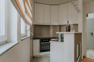 鲁马David 2的厨房配有白色橱柜和炉灶。