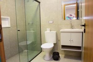 戈亚尼亚Fiori Suítes的一间带卫生间和玻璃淋浴间的浴室