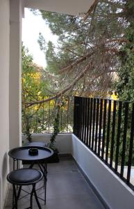 地拉那Studio in Tirana的阳台配有桌子和2把凳子