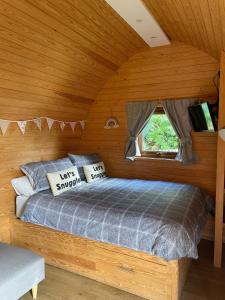 WhitingtonWildflower Meadow Cabins的木制客房内的一间卧室,配有一张床