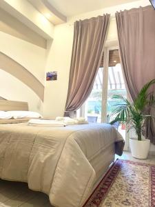 那不勒斯Terrazza Garibaldi的一间卧室设有一张大床和一个大窗户