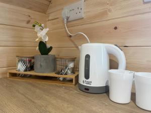 WhitingtonWildflower Meadow Cabins的茶壶和植物台上的咖啡壶