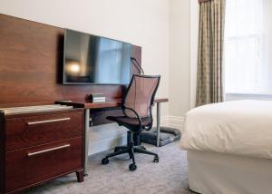 伦敦Club Quarters Hotel Trafalgar Square, London的酒店客房配有书桌、电视和椅子