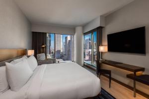 丹佛丹佛市中心万豪AC酒店的酒店客房设有一张大床和一张带窗户的书桌。