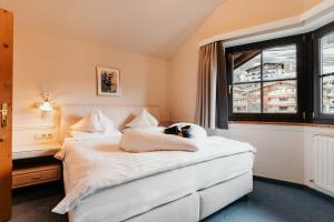 萨尔巴赫Dorfhotel Glücksschmiede的卧室配有白色的床和窗户。