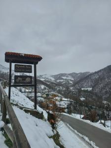 米耶雷斯La Faya - La Vallicuerra Casas Rurales的雪覆盖道路一侧的标志