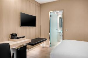 巴塞罗那埃尔拉万豪AC酒店的一间酒店客房,配有一张床和一台电视