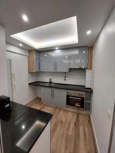 阿尔马达Lisbon South Bay Rooms的厨房配有白色橱柜和不锈钢盥洗盆