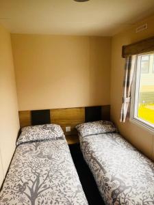 罗切斯特Kent Coast 3 bedroom holiday home的小型客房 - 带2张床和窗户