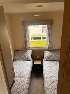 罗切斯特Kent Coast 3 bedroom holiday home的小房间设有两张床和窗户