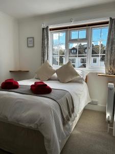 莱姆里吉斯Lucerne B&B的卧室配有一张白色大床和红色毛巾