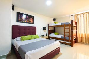 麦德林Ayenda Colombia Avenida的一间卧室配有两张床和一张双层床。