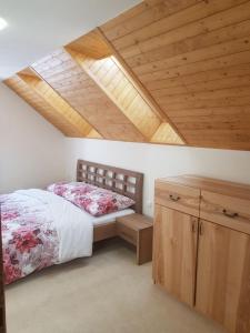 亚诺夫纳德尼索Chalupa Střelenka的一间卧室设有一张床和木制天花板