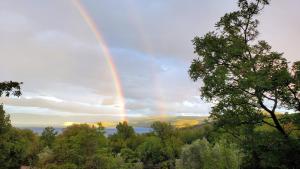 里斯卡Hilltop Villa Risika的天空中带有树木和水的彩虹