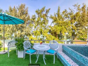 胡鲁马累浮游生物海滩酒店的庭院配有桌椅和遮阳伞。