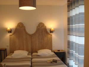 比斯卡罗斯海滩Chambres "Blanches" , bâtiment secondaire hotel la Caravelle, vue jardin的一张带木制床头板的床