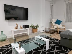 莱昂Casa Roman LUX的客厅配有电视和玻璃茶几