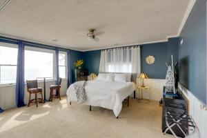 门罗Spacious Lakefront House with Backyard Fire Pit的一间卧室设有一张大床,拥有蓝色的墙壁和窗户。