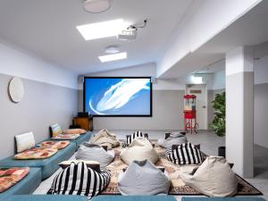 悉尼Stoke Beach House的一间配备有沙发及投影屏幕的房间